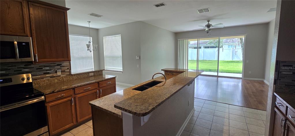 13426 Chariho Lane Windermere, FL 34786 - Photo 64 of 80 a kitchen with granite countertop a sink a counter top space and cabinets