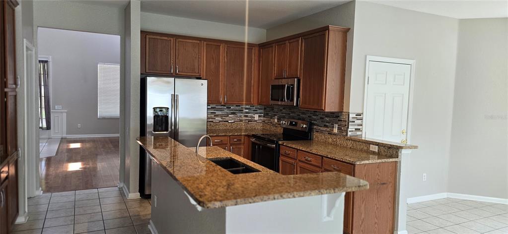 13426 Chariho Lane Windermere, FL 34786 - Photo 66 of 80 a kitchen with stainless steel appliances granite countertop a sink stove and refrigerator