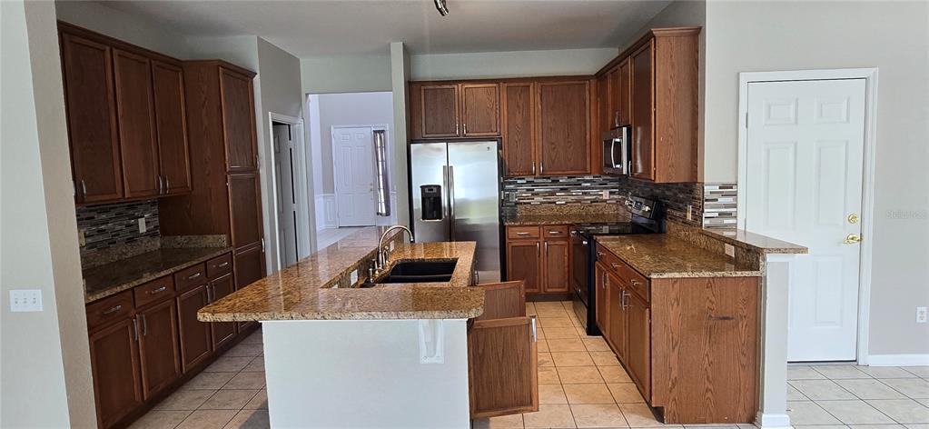 13426 Chariho Lane Windermere, FL 34786 - Photo 68 of 80 a kitchen with stainless steel appliances granite countertop a refrigerator and a stove