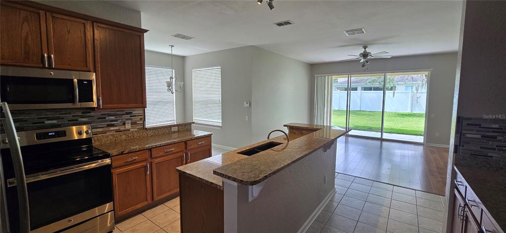 13426 Chariho Lane Windermere, FL 34786 - Photo 73 of 80 a kitchen with granite countertop a stove and a microwave