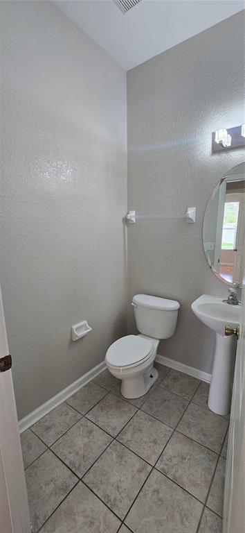 13426 Chariho Lane Windermere, FL 34786 - Photo 74 of 80 a white toilet sitting next to a bathroom sink and a mirror