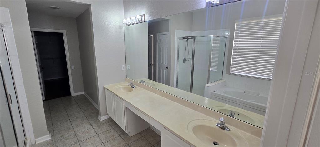 13426 Chariho Lane Windermere, FL 34786 - Photo 80 of 80 a en suite bathroom with a double vanity sink a mirror and a shower