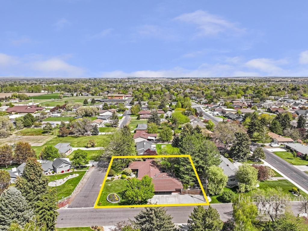 2018 Rancho Vista Drive Twin Falls, ID 83301 - Photo 48 of 50 Aerial perspective showcasing a residential property with a reddish-brown shingled roof, surrounded by mature trees and manicured landscaping