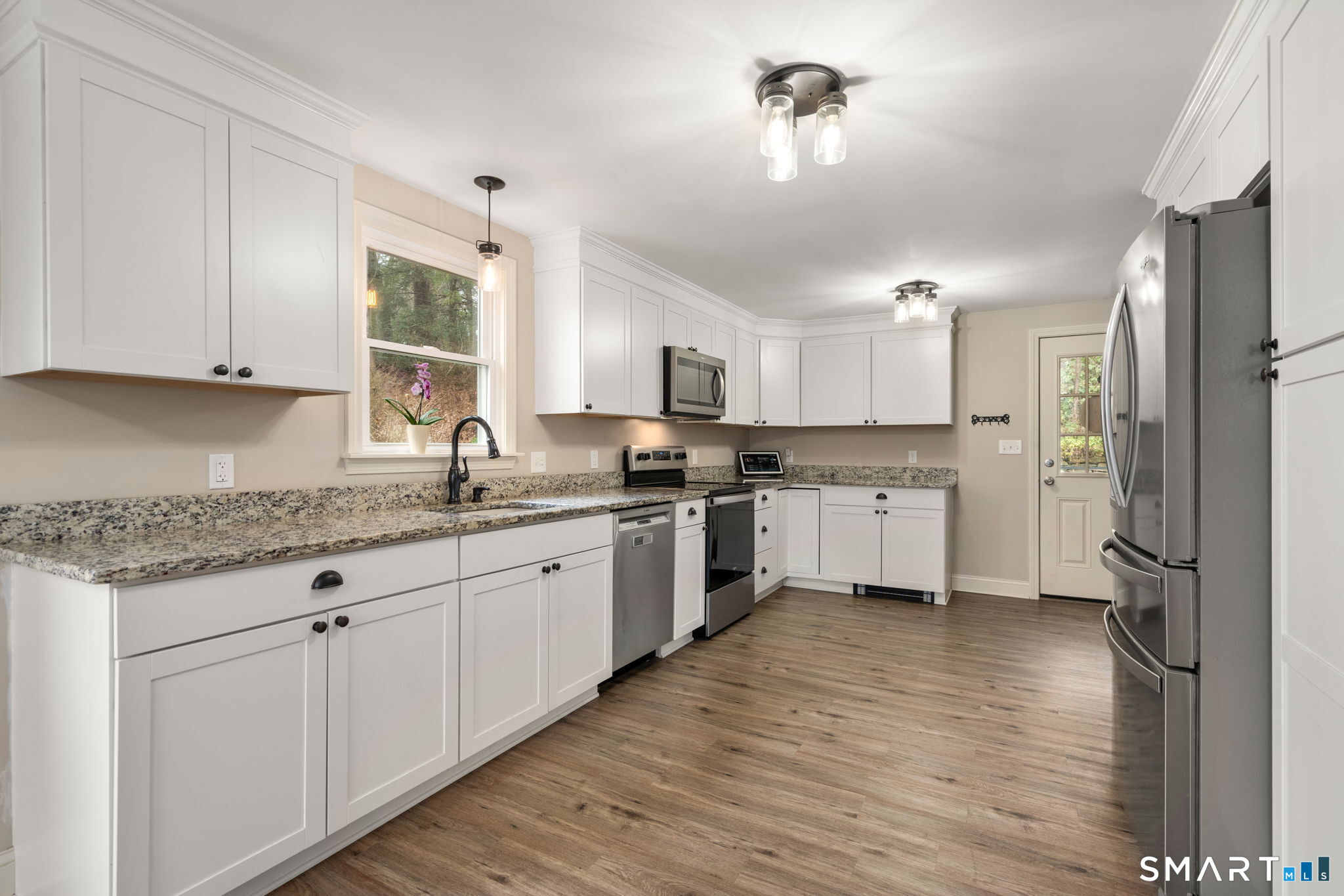 183 Old Hall Road Woodstock, CT 06281 - Photo 14 of 29 a kitchen with granite countertop a refrigerator a sink dishwasher and white cabinets with wooden floor