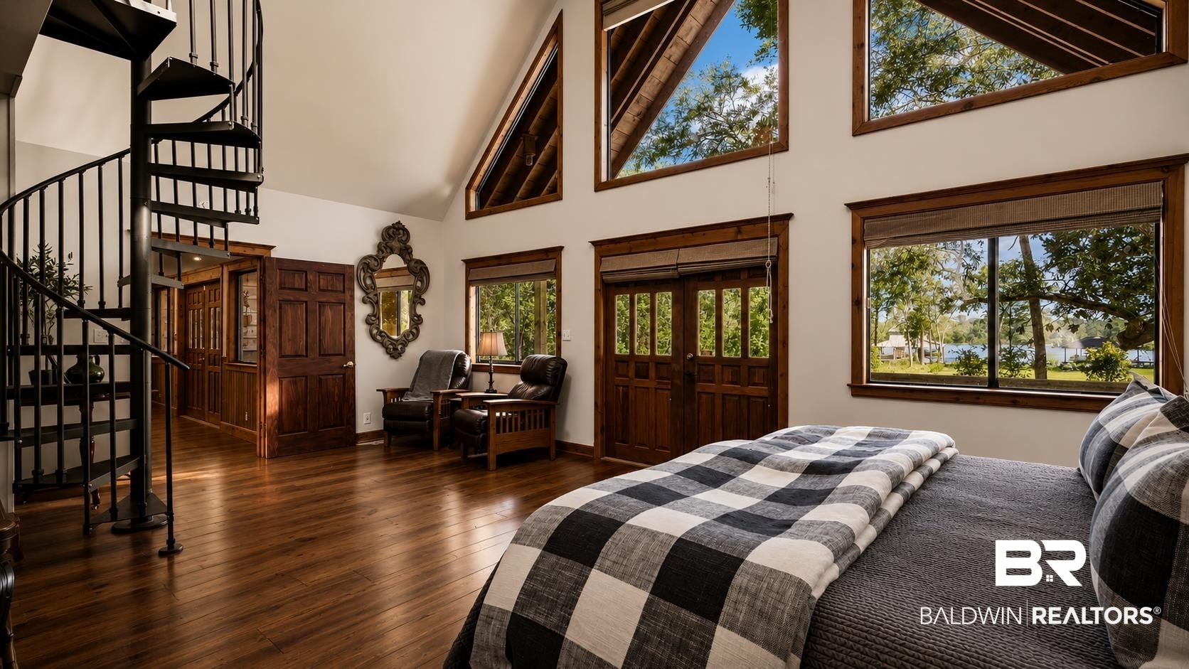 14587 Ridge Road Summerdale, AL 36580 - Photo 21 of 44 Spacious room with wood-finish flooring, a black spiral staircase, and an array of large windows