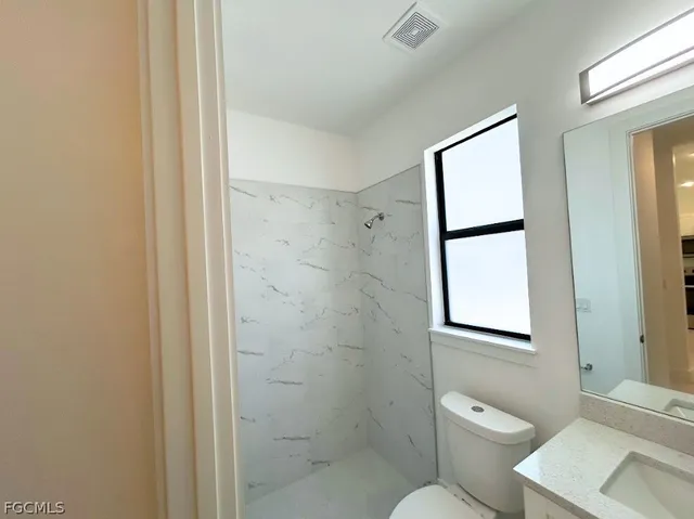 a bathroom with a toilet sink and shower