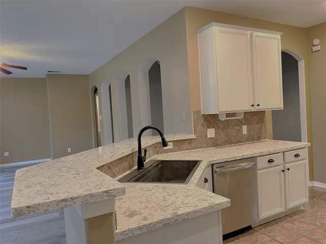 a bathroom with a granite countertop sink a toilet and a tub