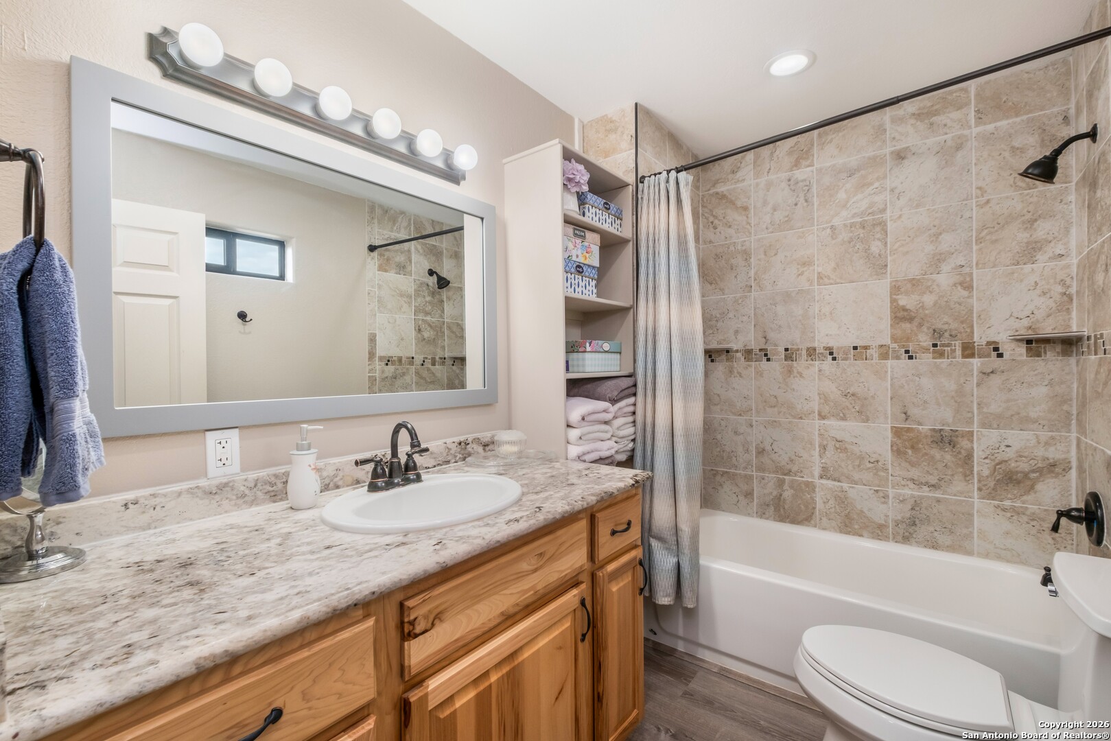 103 Rio Grande Drive Blanco, TX 78606 - Photo 80 of 99 a bathroom with a granite countertop sink a mirror a bathtub and a shower
