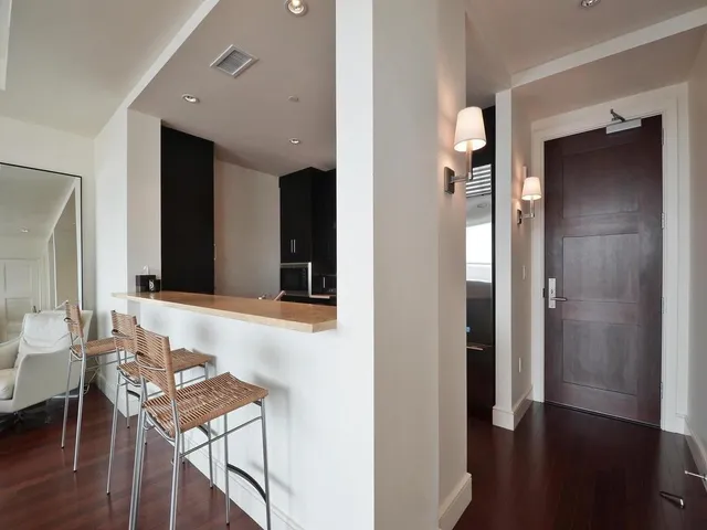 a view of a room with furniture and wooden floor