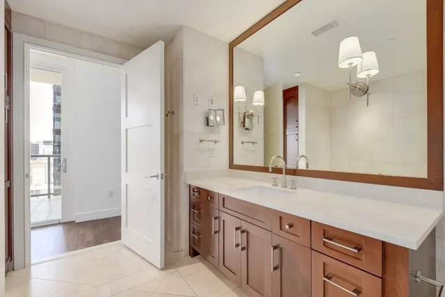 a spacious bathroom with a granite countertop sink a mirror and a shower
