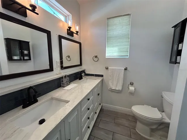 a bathroom with a sink a toilet and mirror