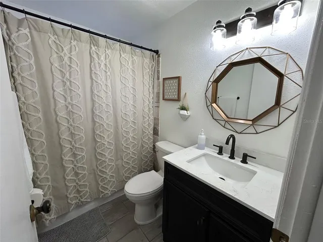 a bathroom with a sink mirror and toilet