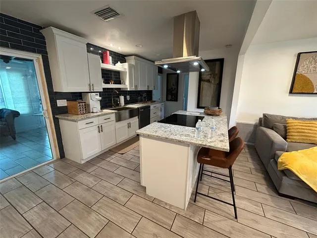 a kitchen with granite countertop a sink cabinets and stainless steel appliances