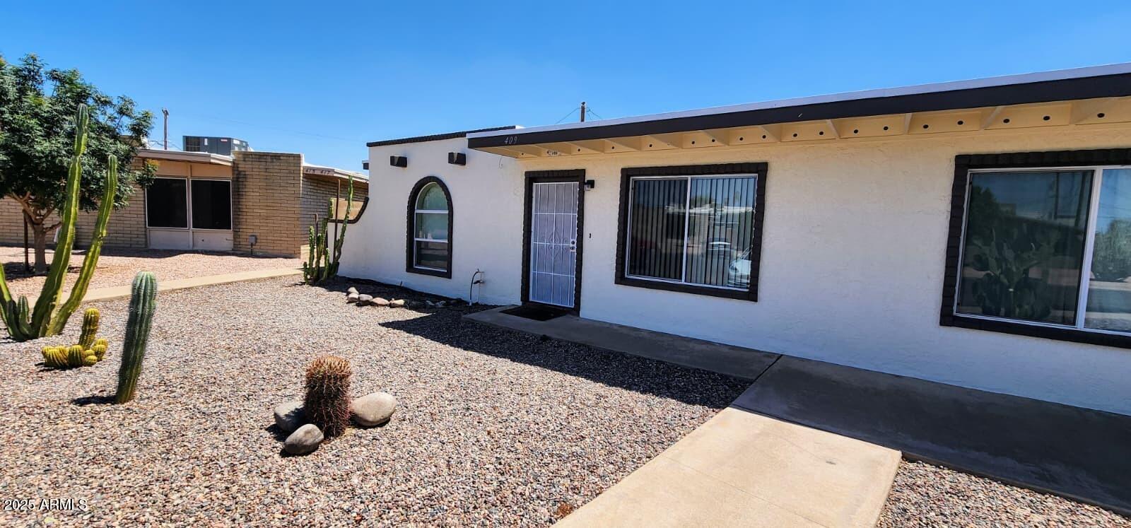 415 East Frost Circle, Unit 419 Mesa, AZ 85203 - Photo 1 of 9 a front view of a house with backyard