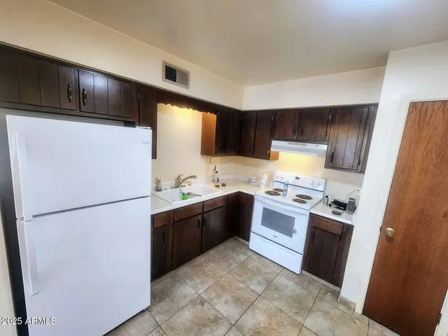 a kitchen with stainless steel appliances granite countertop a refrigerator stove a sink dishwasher and a refrigerator