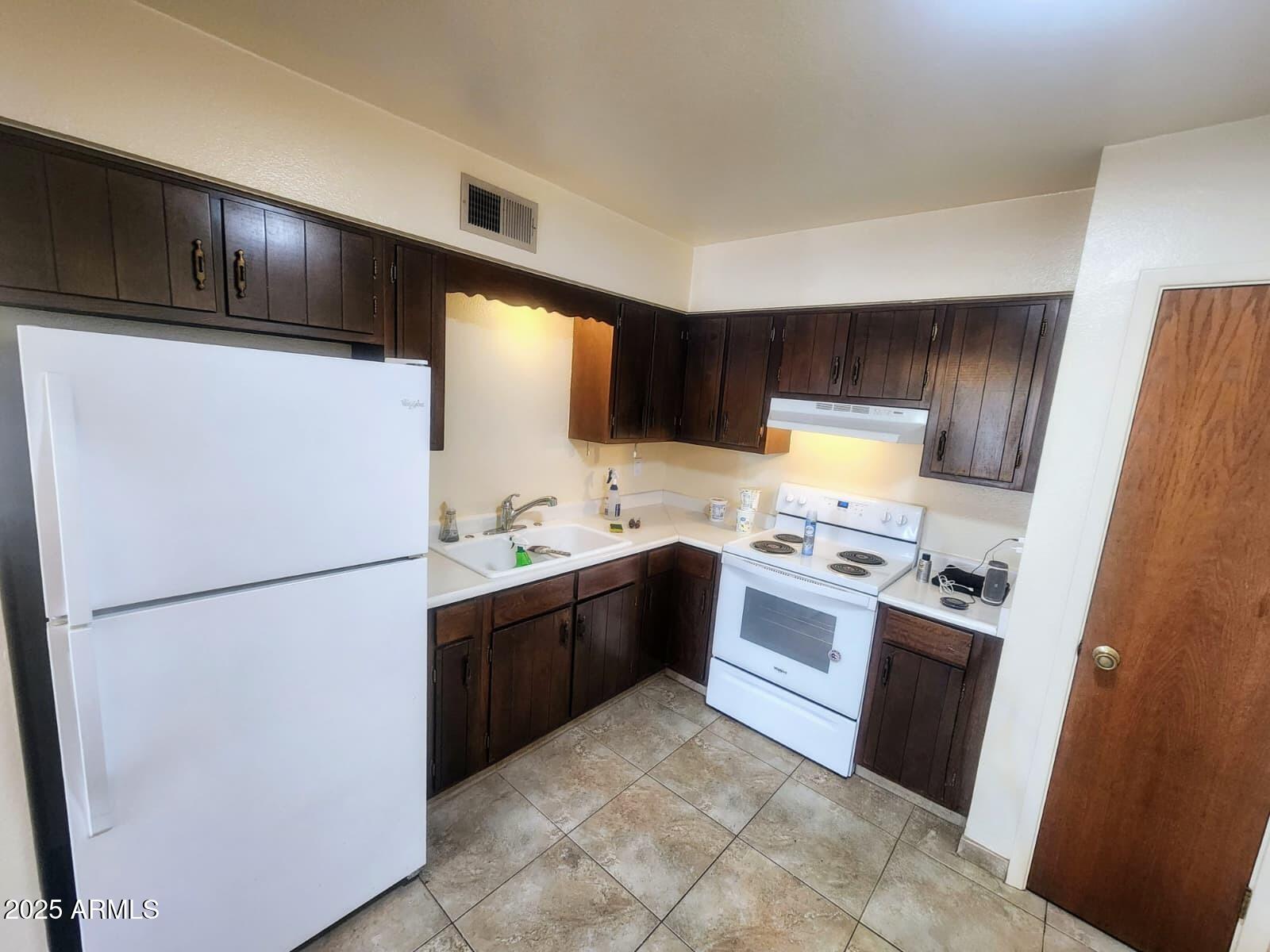 415 East Frost Circle, Unit 419 Mesa, AZ 85203 - Photo 4 of 9 a kitchen with stainless steel appliances granite countertop a refrigerator stove a sink dishwasher and a refrigerator