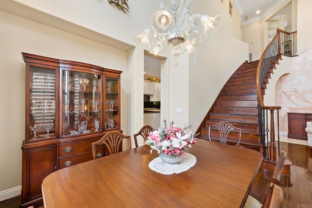 7057 Eider Court Carlsbad, CA 92011 - Photo 16 of 65 a view of a dining room with furniture a chandelier and wooden floor