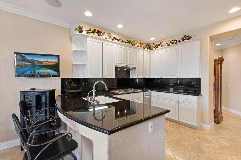 7057 Eider Court Carlsbad, CA 92011 - Photo 18 of 65 a kitchen with stainless steel appliances granite countertop a sink a stove and a refrigerator