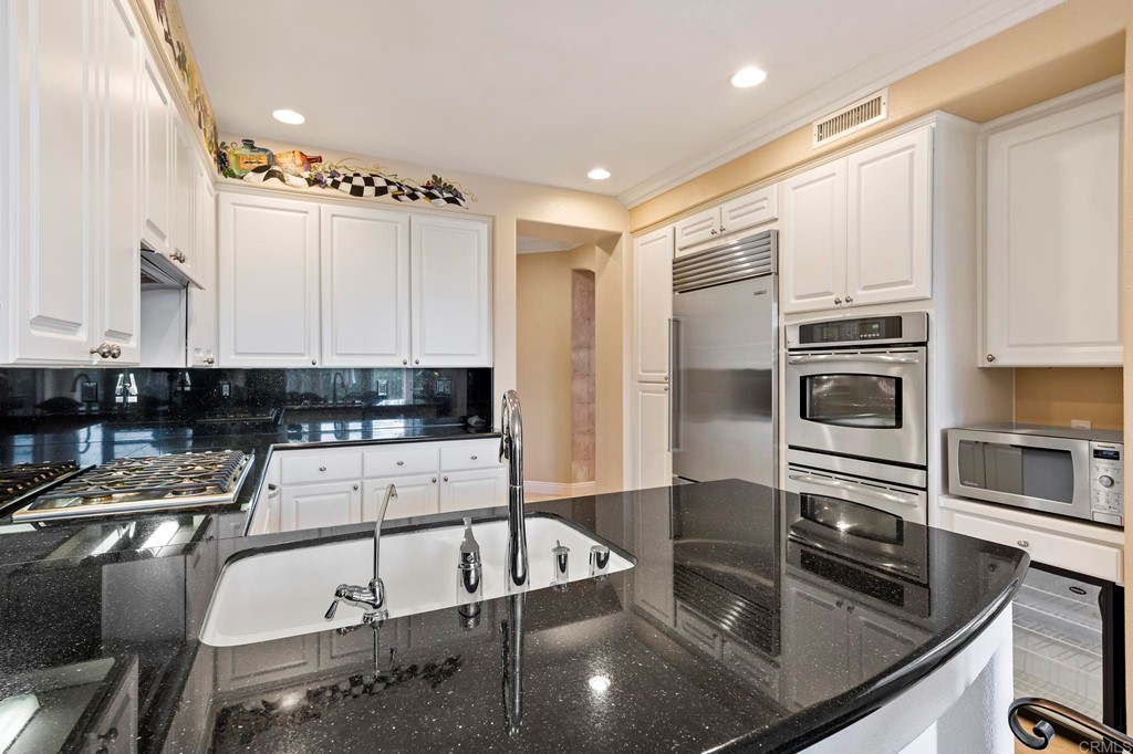7057 Eider Court Carlsbad, CA 92011 - Photo 20 of 65 a kitchen with stainless steel appliances granite countertop a sink a stove and a refrigerator
