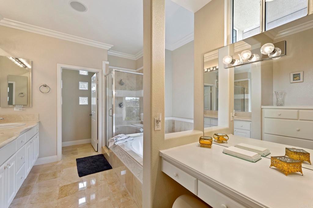 7057 Eider Court Carlsbad, CA 92011 - Photo 33 of 65 a bathroom with a sink a large mirror and a bathtub