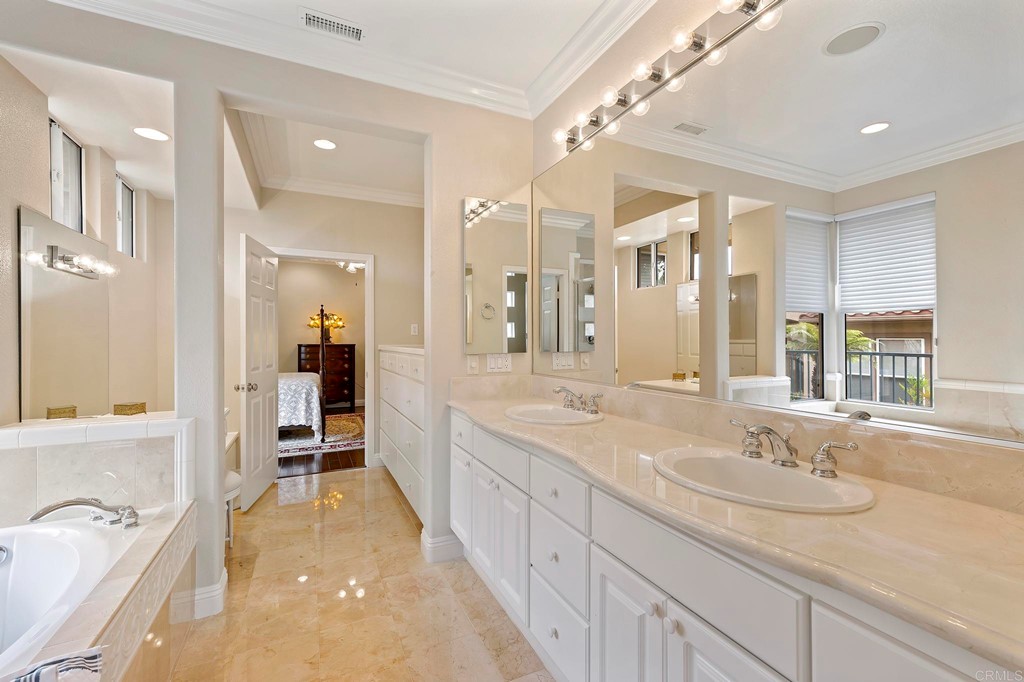 7057 Eider Court Carlsbad, CA 92011 - Photo 36 of 65 a spacious bathroom with a granite countertop sink mirror and a bathtub