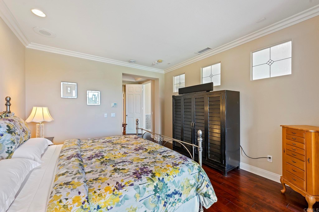 7057 Eider Court Carlsbad, CA 92011 - Photo 45 of 65 a bedroom with a bed and wooden floor