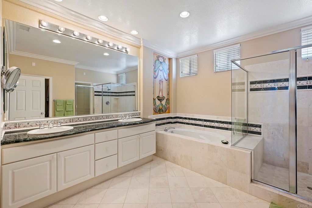 7057 Eider Court Carlsbad, CA 92011 - Photo 47 of 65 a bathroom with a tub a sink and mirror