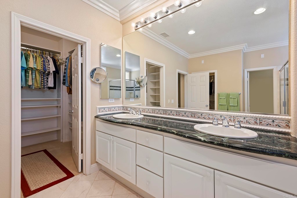 7057 Eider Court Carlsbad, CA 92011 - Photo 50 of 65 a bathroom with a granite countertop sink and a mirror