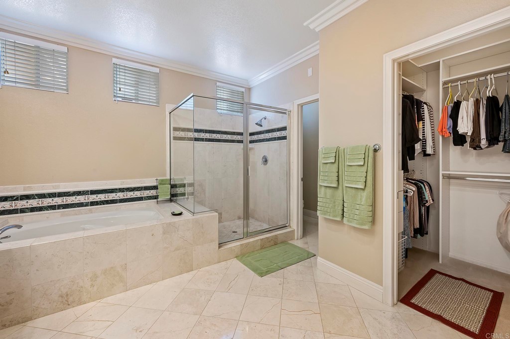 7057 Eider Court Carlsbad, CA 92011 - Photo 51 of 65 a bathroom with a tub and a shower