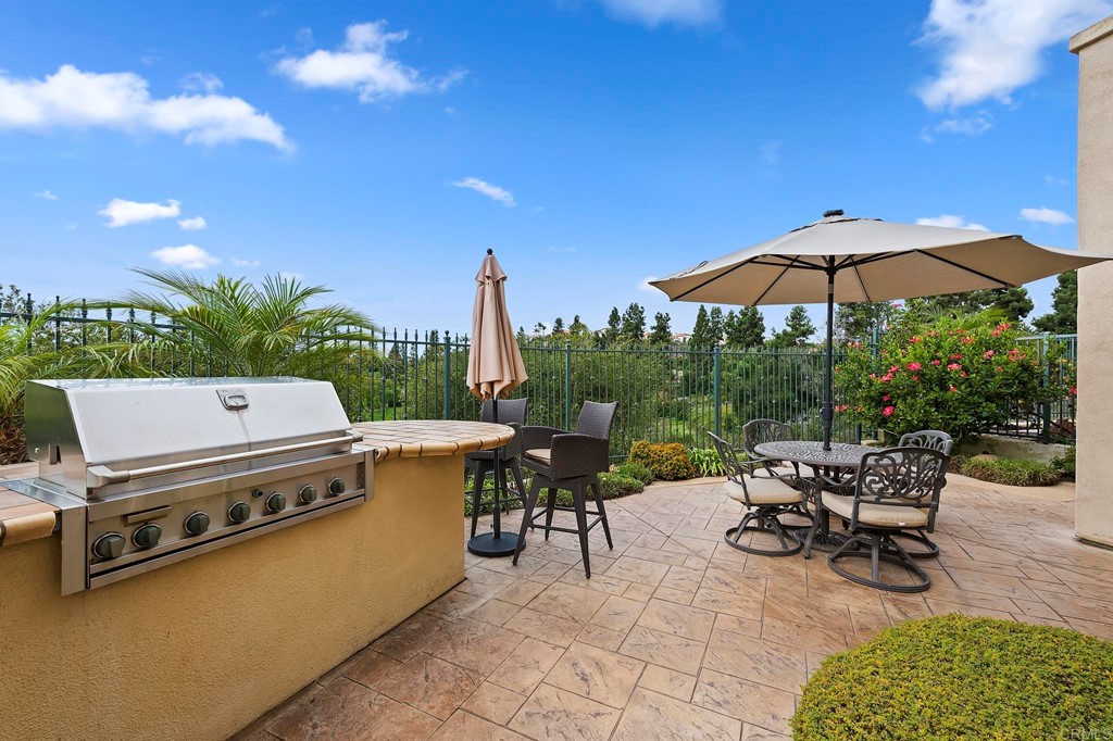 7057 Eider Court Carlsbad, CA 92011 - Photo 57 of 65 a view of a patio with a table and chairs under an umbrella