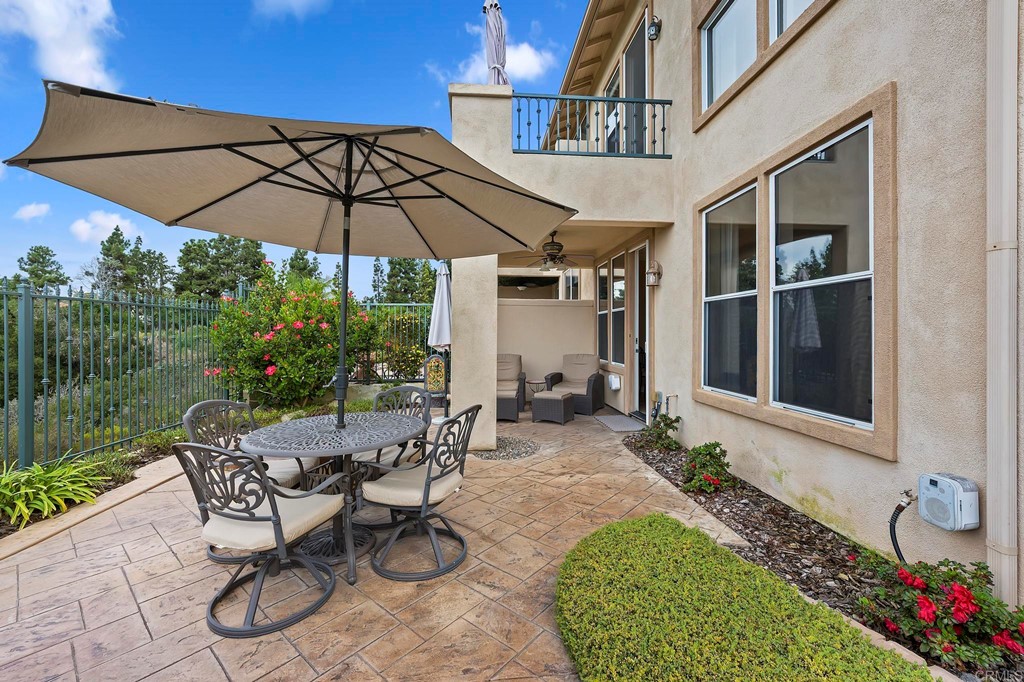 7057 Eider Court Carlsbad, CA 92011 - Photo 58 of 65 a view of a patio with table and chairs under an umbrella