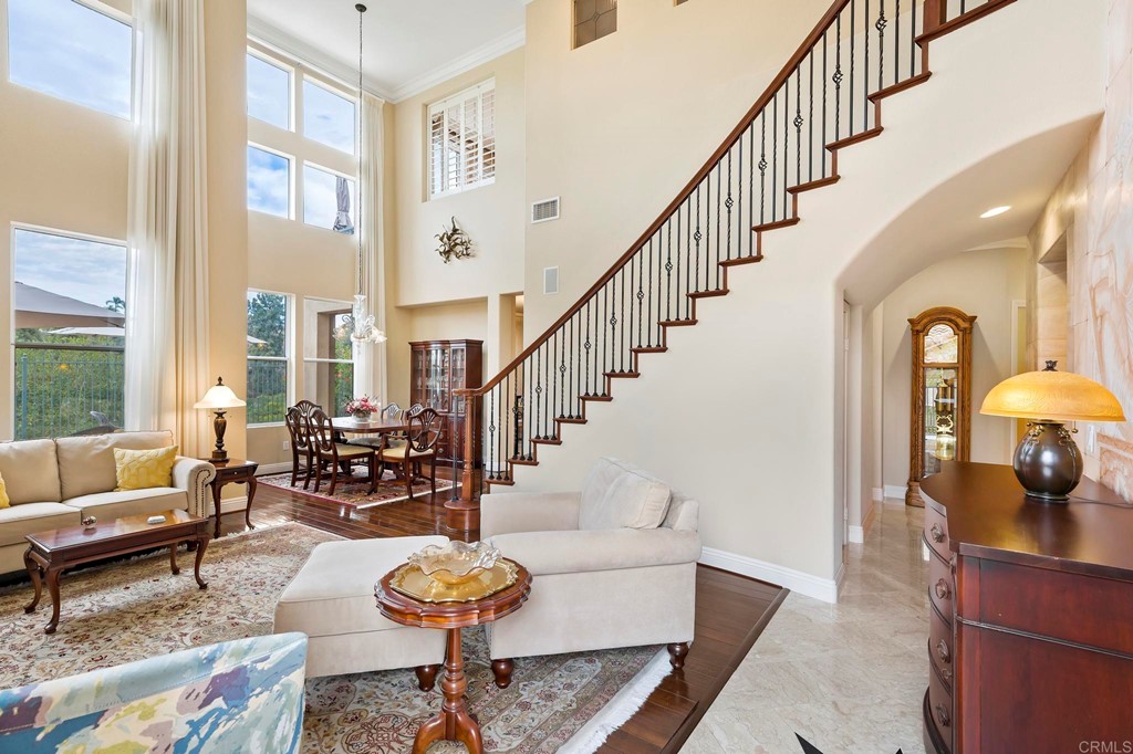 7057 Eider Court Carlsbad, CA 92011 - Photo 10 of 65 a living room with furniture a rug chandelier and a large window