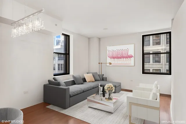 a living room with furniture a lamp paintings and a window