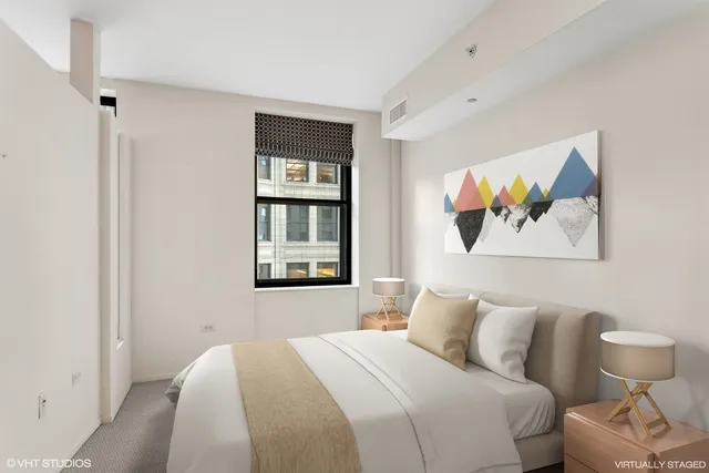 a bedroom with a bed and a painting on the wall