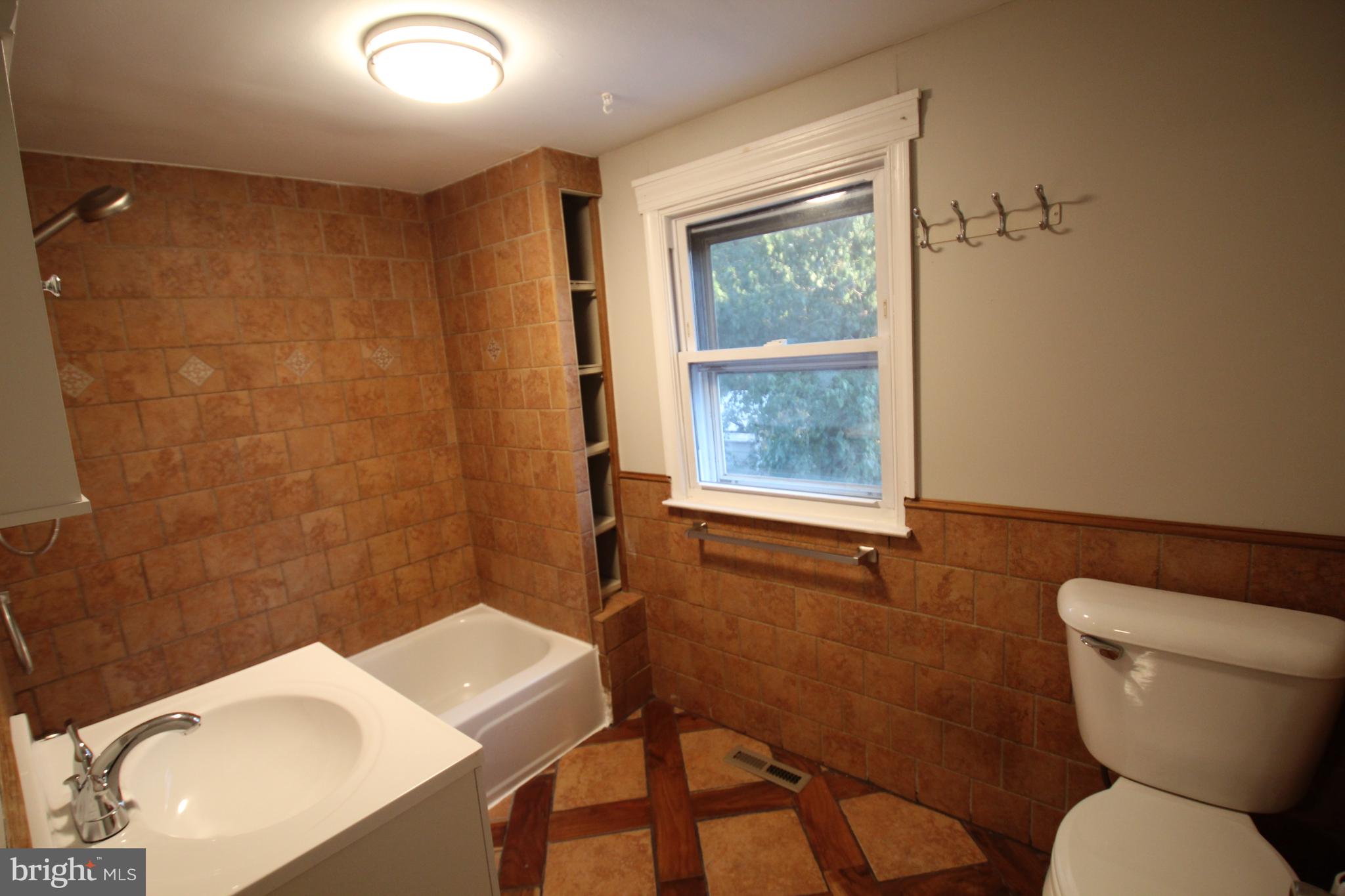 25 East 4th Street New Castle, DE 19720 - Photo 19 of 22 a bathroom with a toilet a sink and a shower