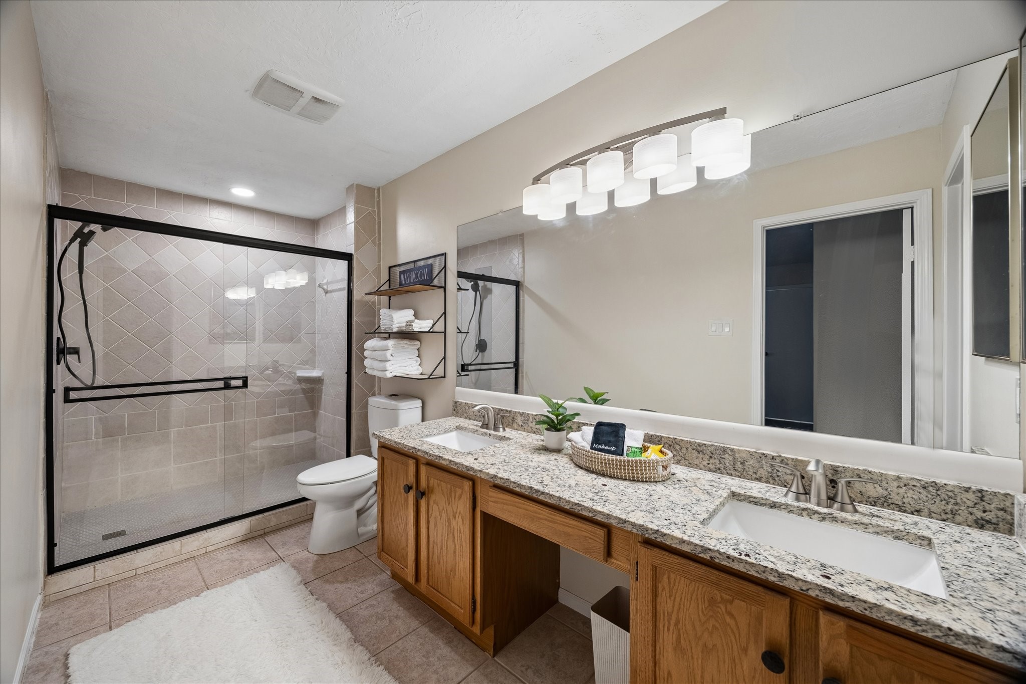 30 Camberwell Court The Woodlands, TX 77380 - Photo 15 of 26 a bathroom with a granite countertop sink a toilet a mirror and shower