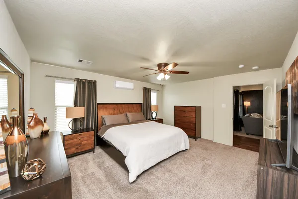 a bedroom with a large bed and a chandelier