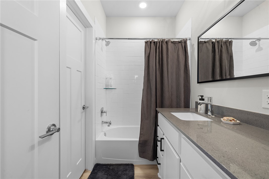 767 Double Mountain Road College Station, TX 77845 - Photo 16 of 34 a bathroom with a granite countertop sink a mirror a shower and a bathtub