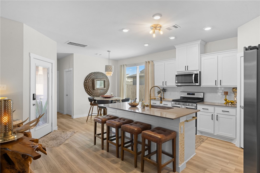 767 Double Mountain Road College Station, TX 77845 - Photo 8 of 34 a kitchen with kitchen island granite countertop a stove a sink a dining table and chairs