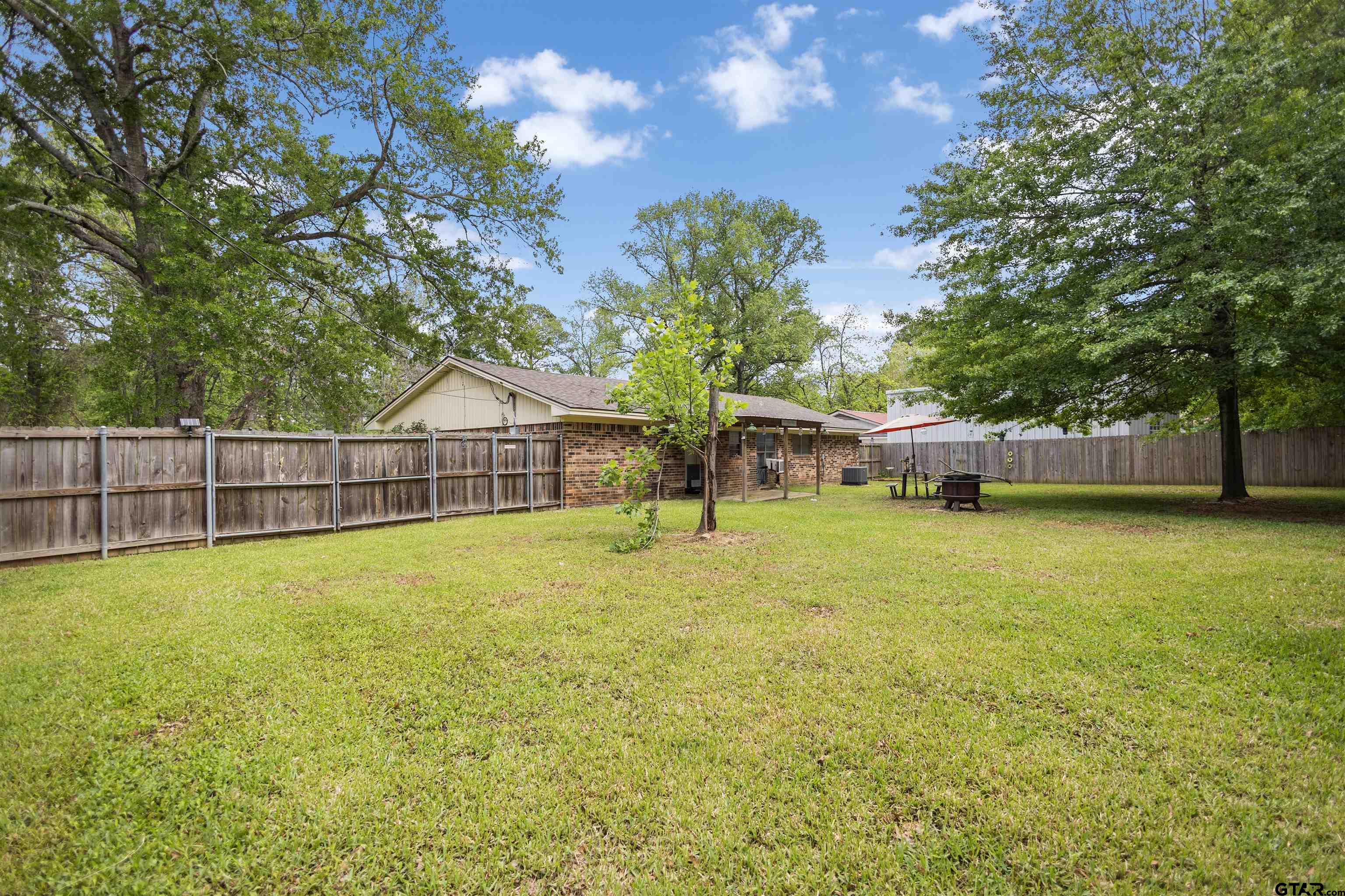 607 Beverly Drive Carthage, TX 75633 - Photo 6 of 11 a view of a house with backyard and tree