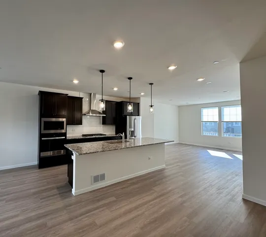a kitchen with stainless steel appliances a refrigerator and a stove top oven