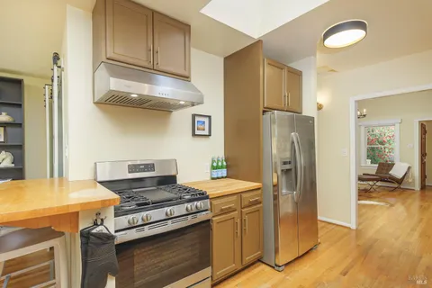 a kitchen with stainless steel appliances granite countertop a refrigerator and a stove top oven