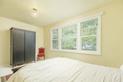 a bedroom with a bed and a large window
