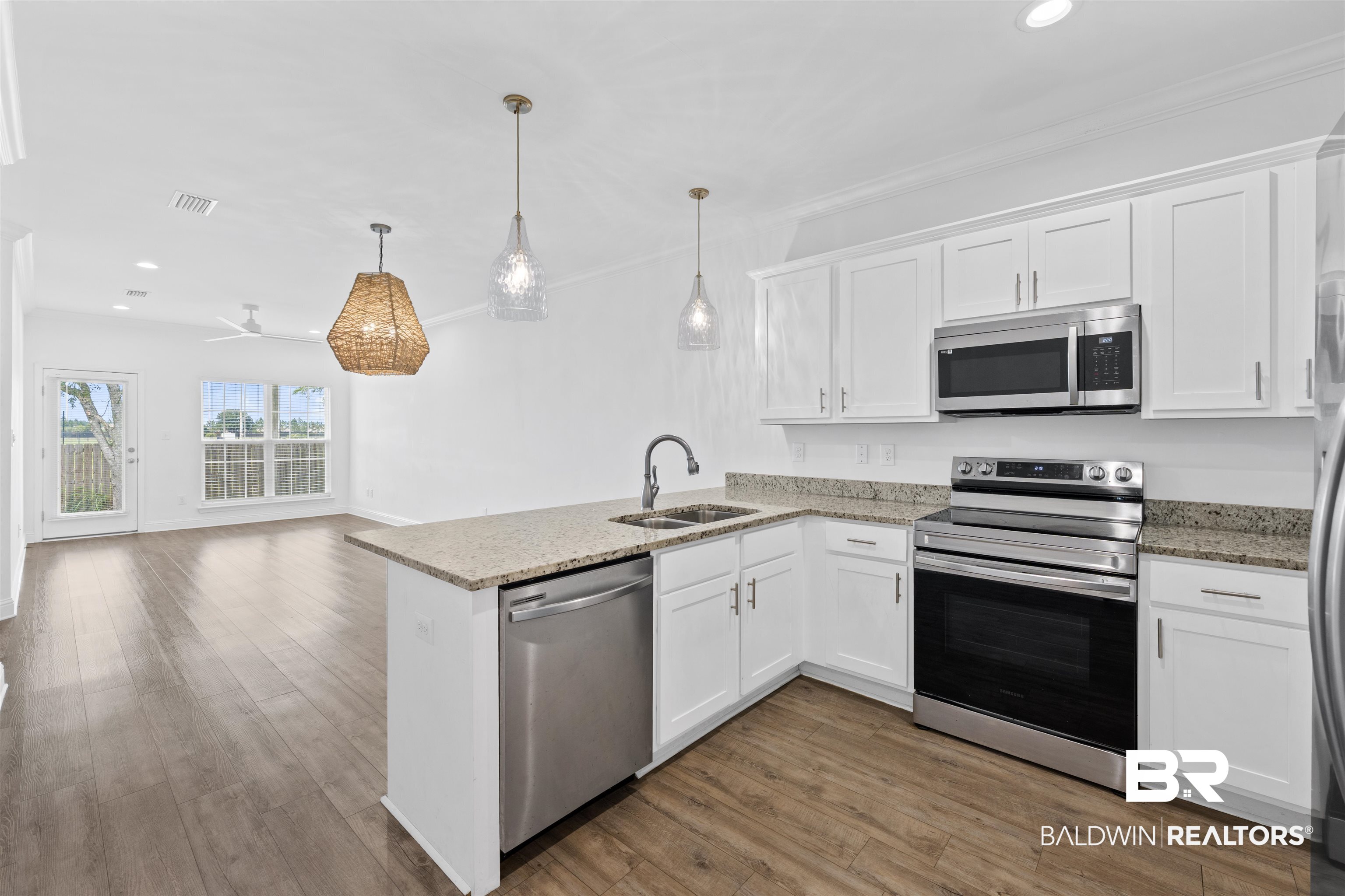 2651 South Juniper Street, Unit 1801 Foley, AL 36535 - Photo 5 of 16 Open-concept kitchen featuring white shaker cabinetry, stainless steel appliances, and granite countertops