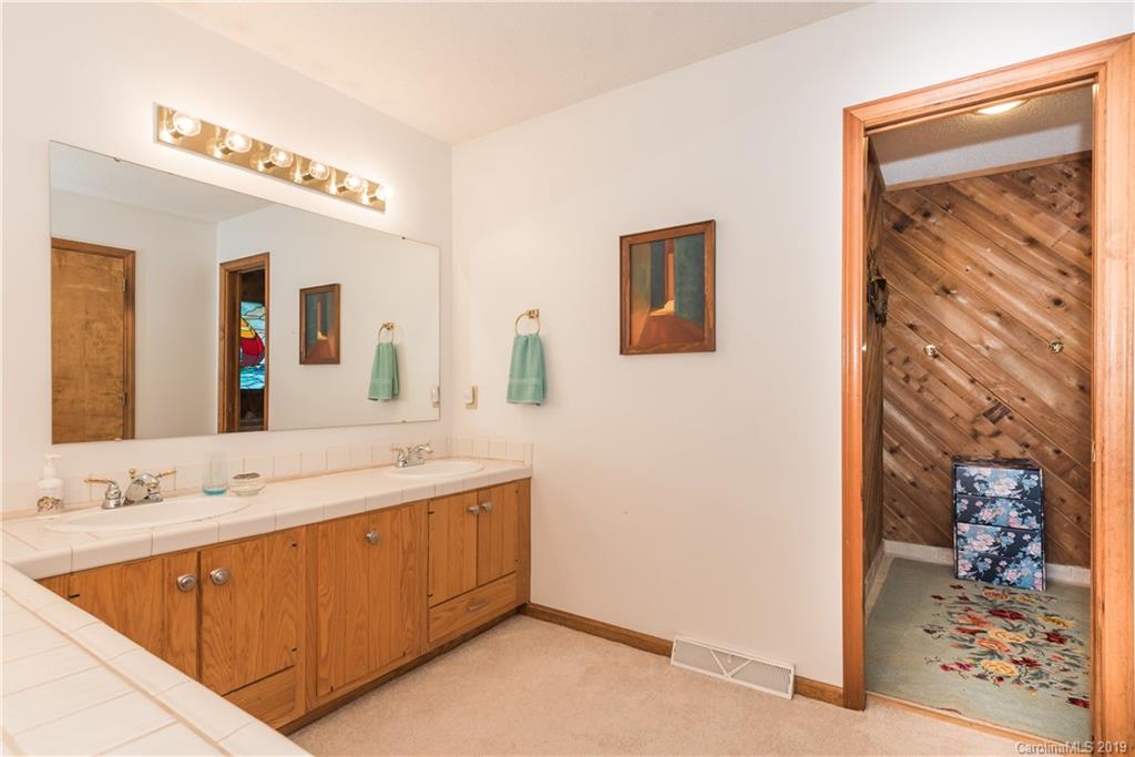 29040 Snapper Point Tega Cay, SC 29708 - Photo 22 of 39 a bathroom with a sink a mirror and a shower