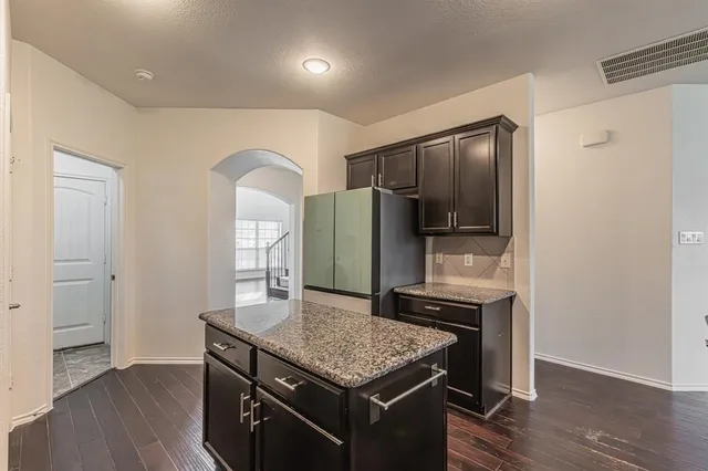 a kitchen with stainless steel appliances granite countertop a refrigerator and a stove