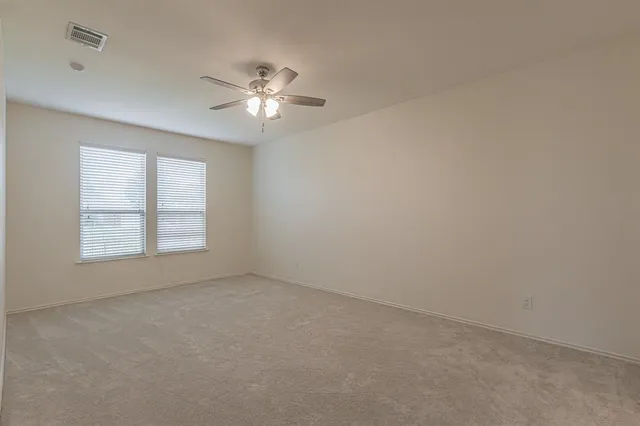 an empty room with a window and a fan