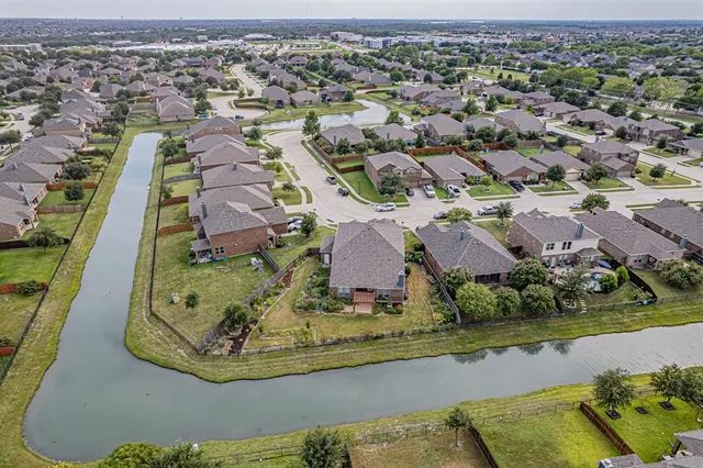 an aerial view of a house with a lake