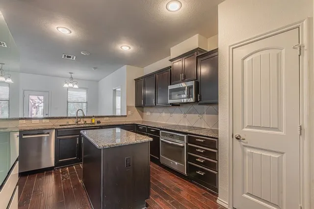 a kitchen with stainless steel appliances granite countertop stove top oven and refrigerator