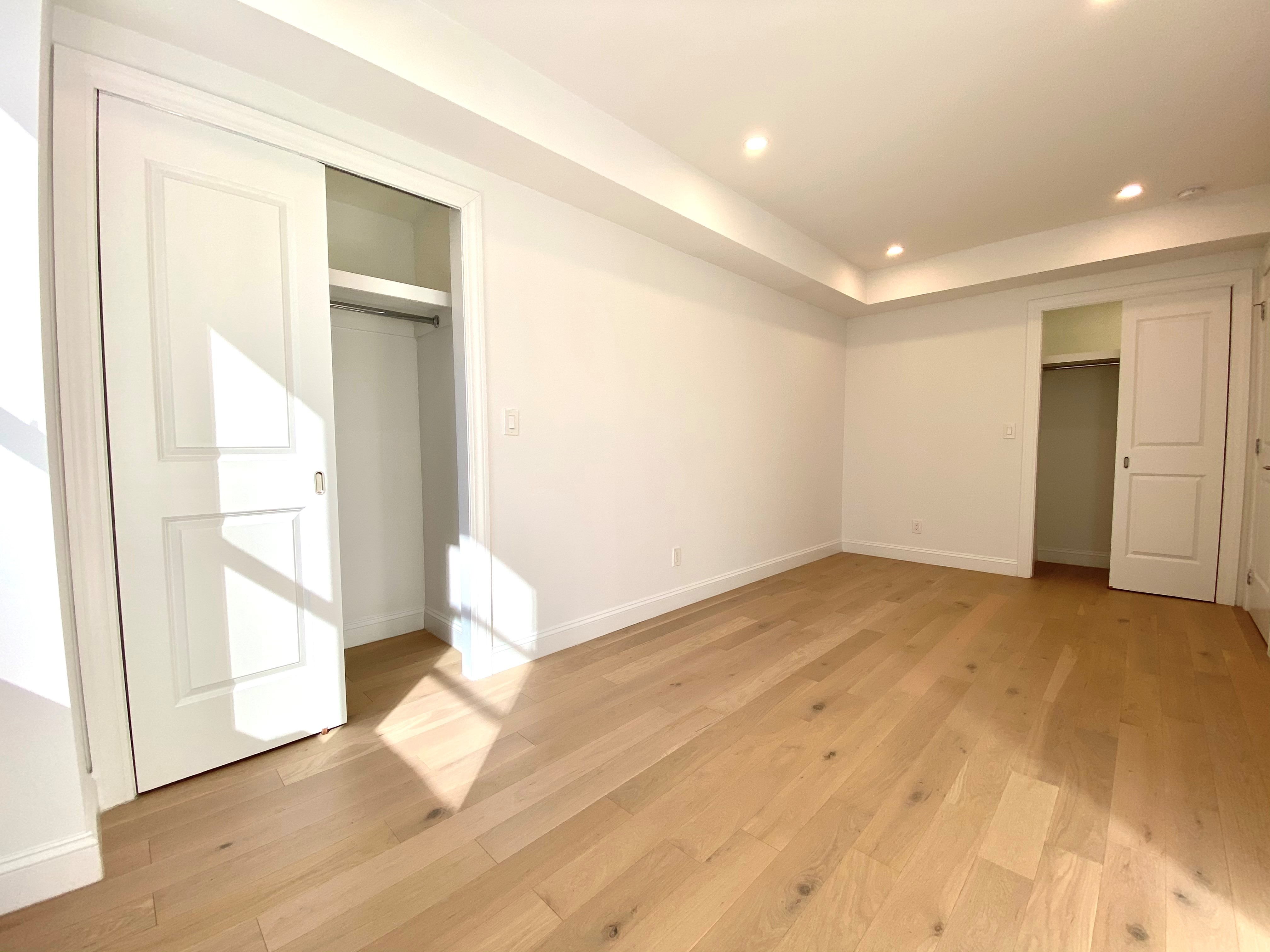 an empty room with wooden floor and door